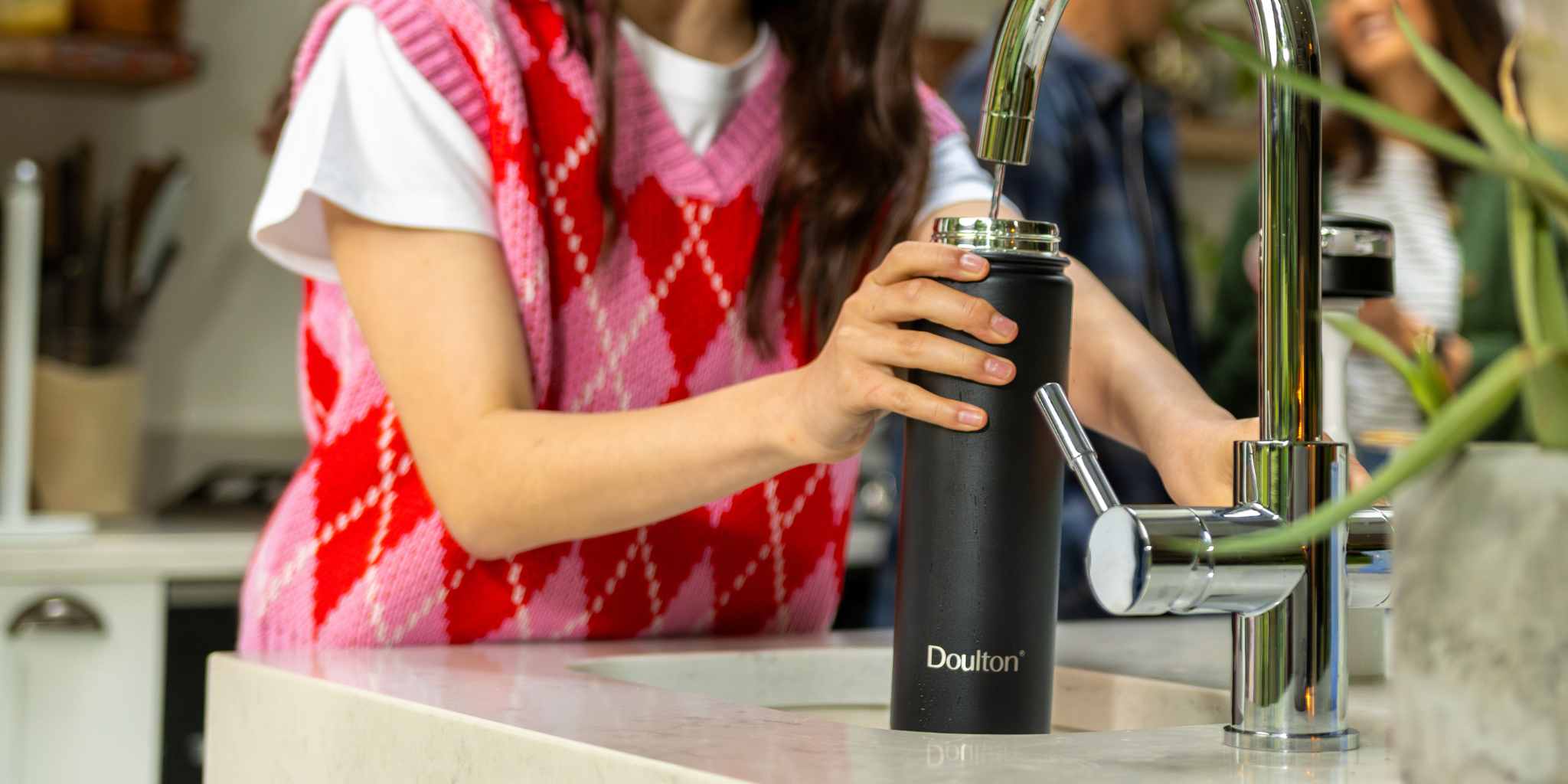 girl pouring water into a doulton branded bottle