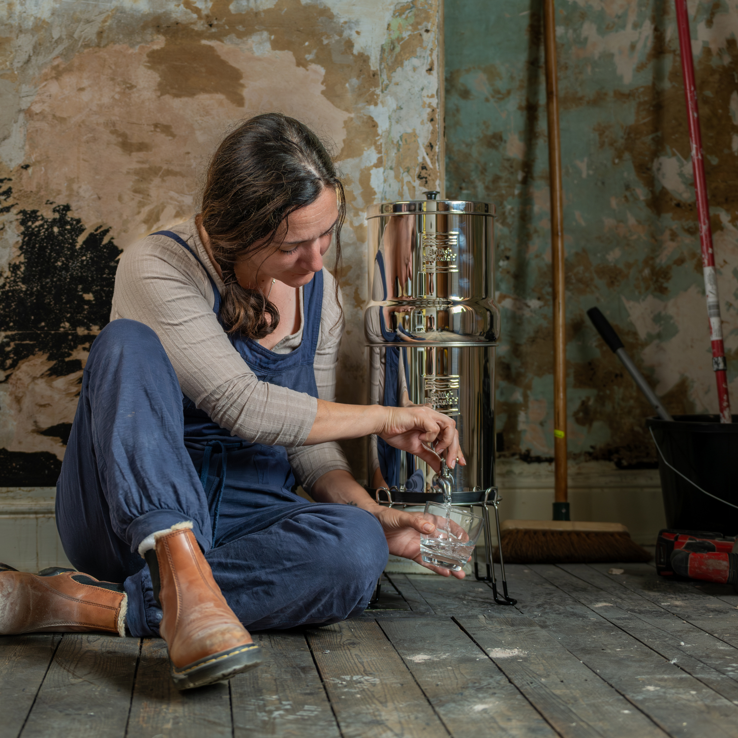 woman getting a glass of water from a gravity water system