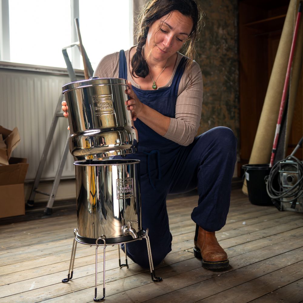 Woman handling a large metal water filter system 