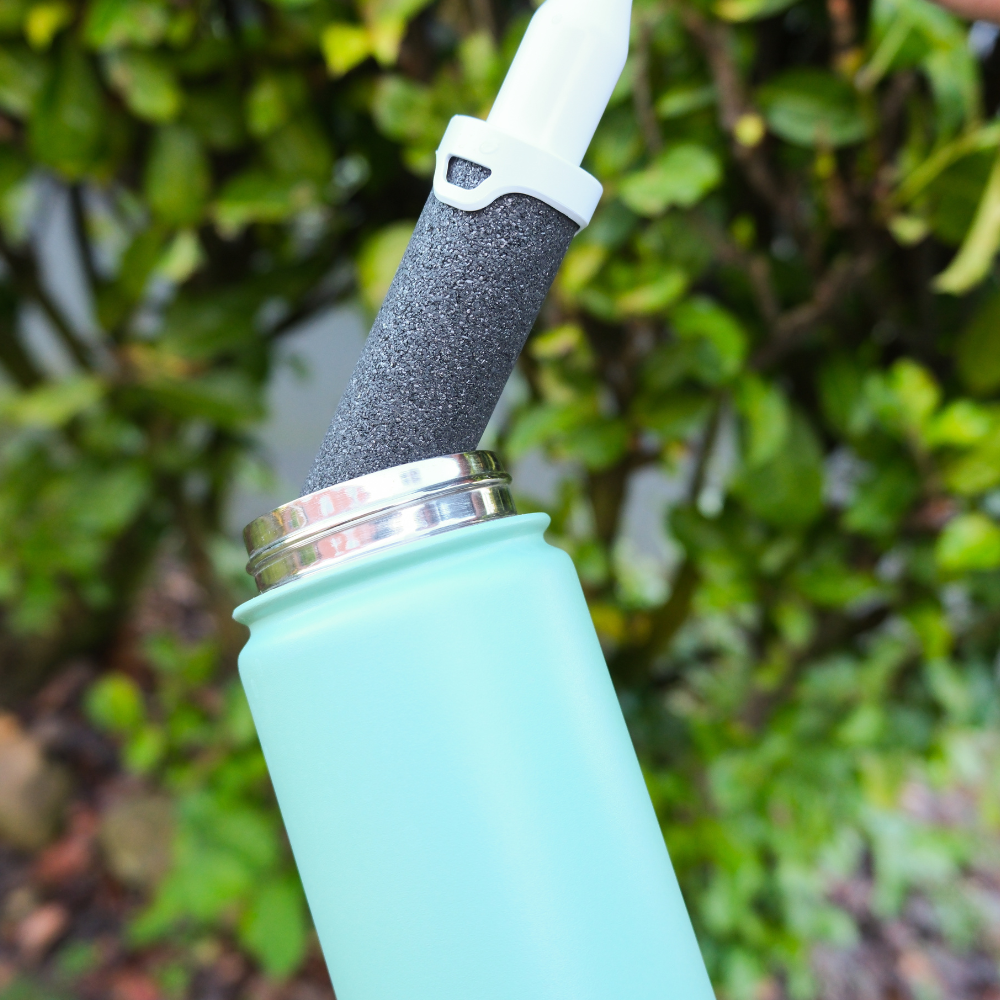 Close up of new Doulton water bottle filter being placed inside green Doulton bottle