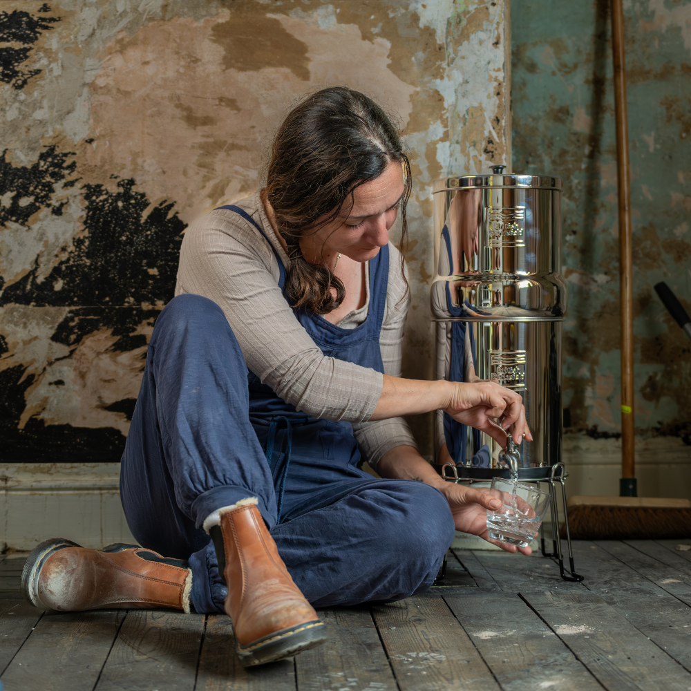 A woman getting water from a gravity water system 